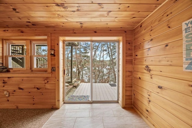 entryway with light tile patterned floors, wooden ceiling, and wood walls