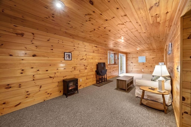 sitting room featuring carpet flooring, a wood stove, wooden walls, and wooden ceiling