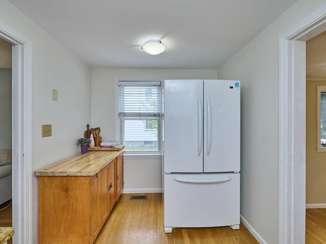 440 Forest St, Waltham, MA 02452 - kitchen featuring freestanding refrigerator, light wood-style floors, baseboards, brown cabinetry, and wooden counters