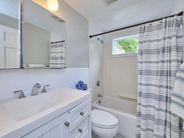 440 Forest St, Waltham, MA 02452 - full bath featuring shower / tub combo with curtain, vanity, toilet, and tile walls
