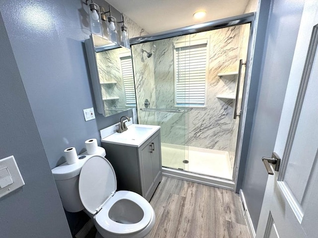 full bathroom featuring a marble finish shower, vanity, toilet, and wood finished floors