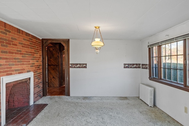 unfurnished dining area featuring radiator, brick wall, and a fireplace