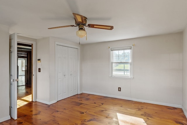 unfurnished bedroom featuring a closet, hardwood / wood-style flooring, and ceiling fan