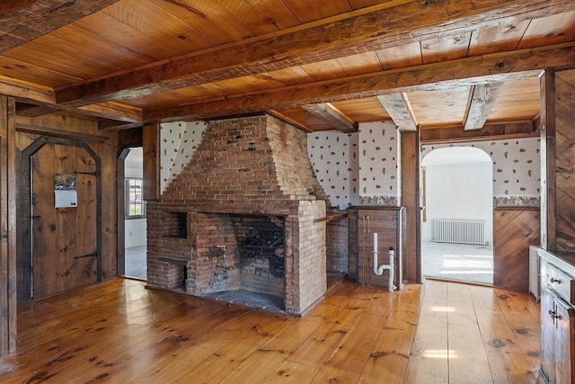 unfurnished living room with wood ceiling, light wood-type flooring, and wooden walls