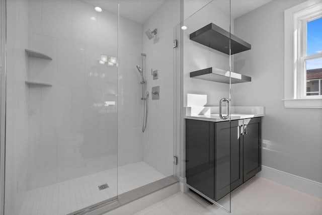 bathroom with tile patterned flooring, vanity, and walk in shower