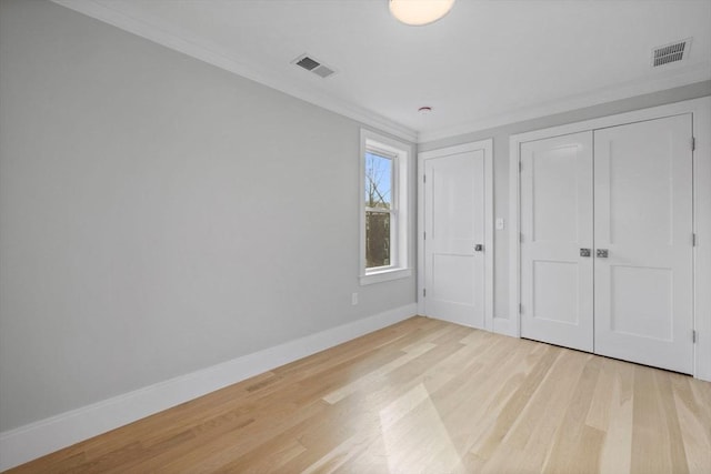 unfurnished bedroom featuring a closet, crown molding, and light hardwood / wood-style flooring