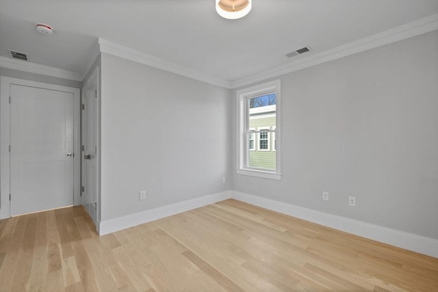 empty room with light hardwood / wood-style flooring and crown molding