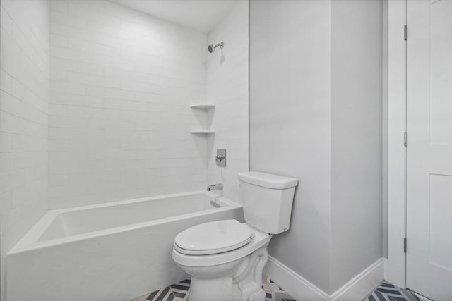 bathroom featuring tile patterned flooring, toilet, and bathtub / shower combination