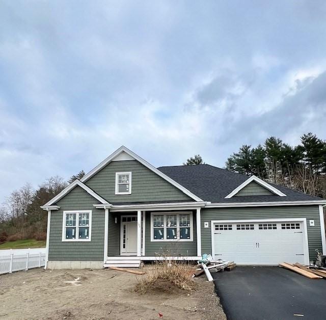 view of front of home featuring a garage, a shingled roof, and aphalt driveway