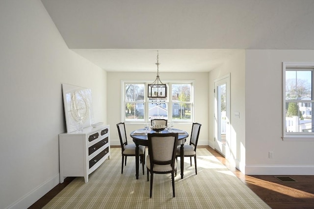 dining area with hardwood / wood-style floors and a chandelier