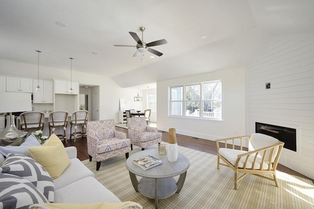 living room with hardwood / wood-style floors, a large fireplace, ceiling fan, and lofted ceiling