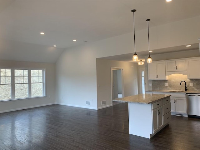 kitchen featuring a center island, hanging light fixtures, stainless steel dishwasher, open floor plan, and white cabinetry