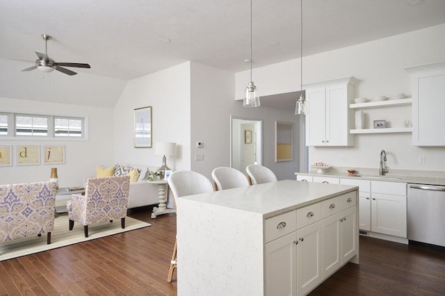 kitchen featuring sink, decorative light fixtures, dishwasher, white cabinetry, and a breakfast bar area