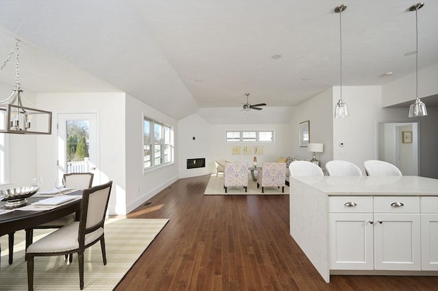 interior space featuring white cabinets, ceiling fan, dark hardwood / wood-style flooring, and hanging light fixtures