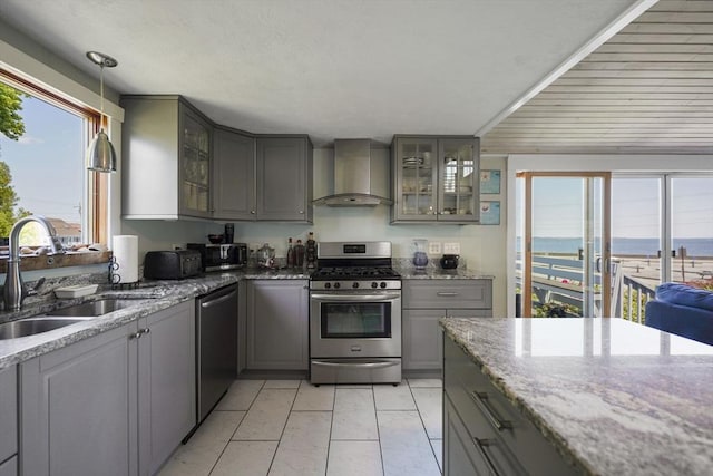 21 Hudson St, New Bedford, MA 02744 - kitchen with gray cabinetry, wall chimney exhaust hood, appliances with stainless steel finishes, a sink, and plenty of natural light