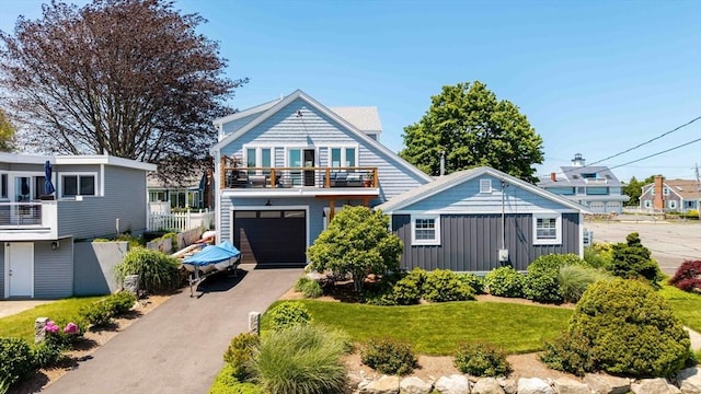 21 Hudson St, New Bedford, MA 02744 - view of front facade with a balcony, asphalt driveway, an attached garage, and board and batten siding