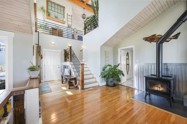 21 Hudson St, New Bedford, MA 02744 - foyer entrance featuring high vaulted ceiling, stairway, hardwood / wood-style floors, and a wood stove