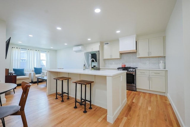 307 E Eagle St, Boston, MA 02128 - kitchen with appliances with stainless steel finishes, an AC wall unit, custom exhaust hood, light wood finished floors, and backsplash