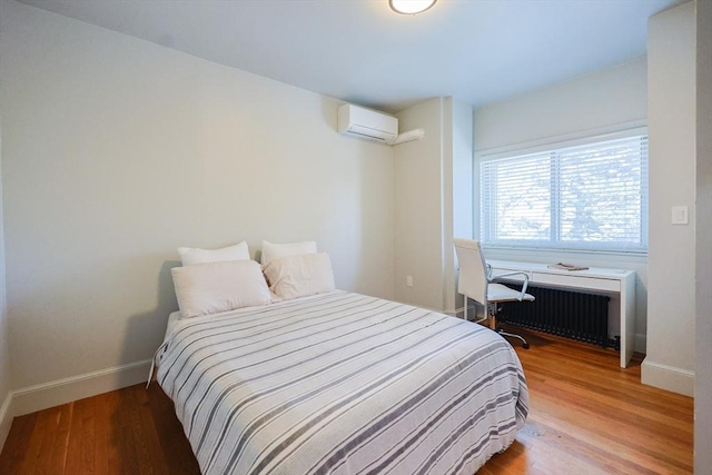 307 E Eagle St, Boston, MA 02128 - bedroom with radiator heating unit, a wall unit AC, and light wood finished floors