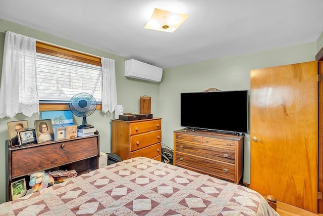 bedroom with an AC wall unit and hardwood / wood-style flooring