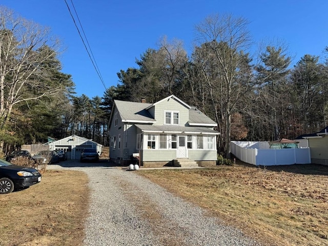 front facade with a garage and an outbuilding