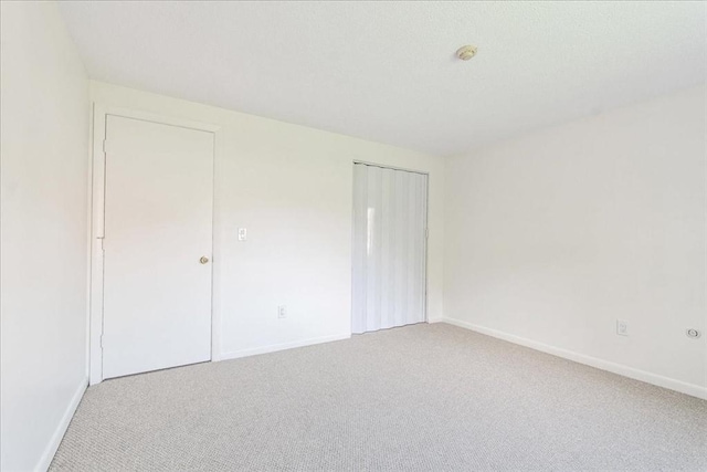 unfurnished bedroom featuring carpet flooring, a closet, and baseboards