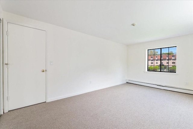 carpeted empty room with baseboards and a baseboard heating unit
