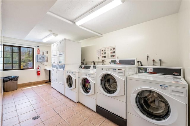 common laundry area featuring light tile patterned floors, baseboards, washer and dryer, and stacked washer / dryer