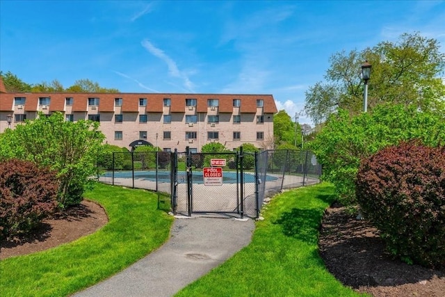 view of home's community with a yard, fence, and a gate