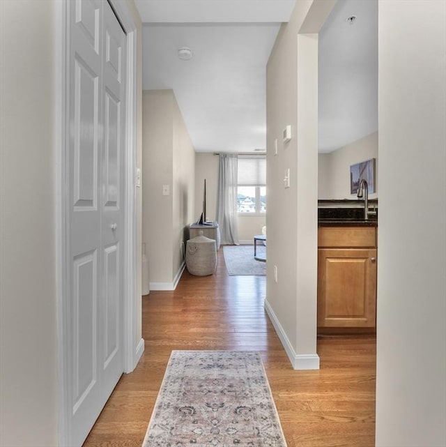 hallway featuring sink and light hardwood / wood-style flooring