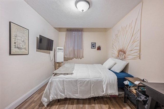 bedroom featuring wood finished floors and baseboards