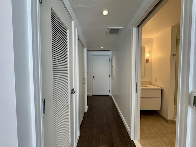 corridor with a heating unit, baseboards, recessed lighting, and wood finished floors