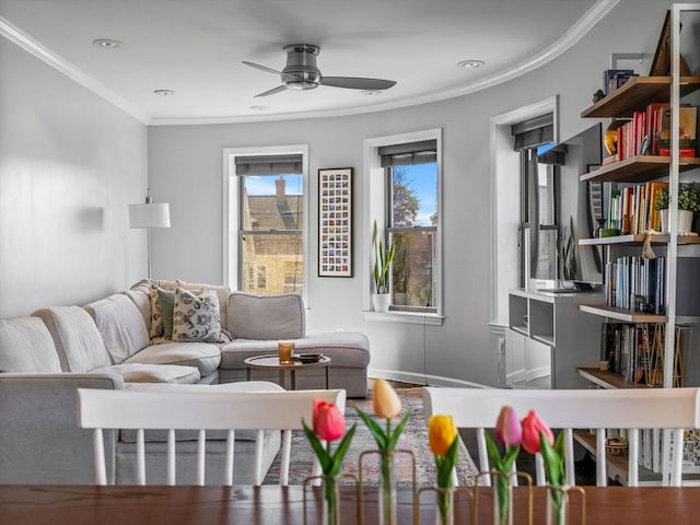 living area with ceiling fan, crown molding, and baseboards