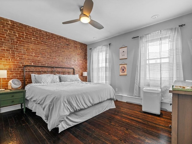 bedroom featuring brick wall, hardwood / wood-style flooring, and a ceiling fan