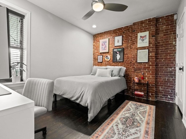 bedroom featuring brick wall, dark wood finished floors, recessed lighting, and a ceiling fan