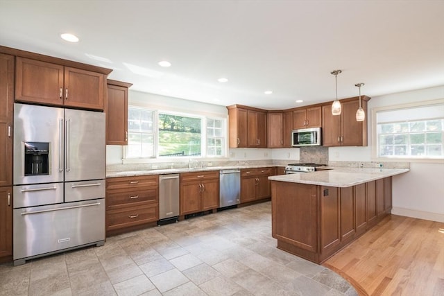 26 N Hillside Rd, Deerfield, MA 01373 - kitchen with stainless steel appliances, a peninsula, brown cabinetry, decorative light fixtures, and recessed lighting