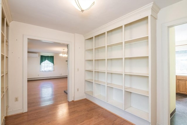 26 N Hillside Rd, Deerfield, MA 01373 - hallway featuring a baseboard heating unit, an AC wall unit, wood finished floors, and a chandelier