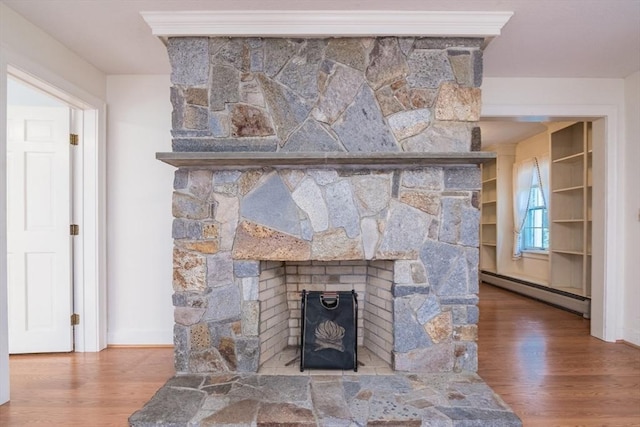 26 N Hillside Rd, Deerfield, MA 01373 - detailed view of a baseboard radiator, wood finished floors, and a stone fireplace