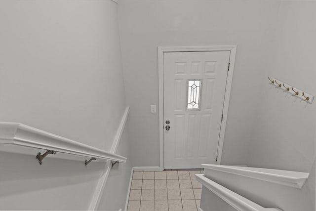 foyer featuring light tile patterned floors and baseboards