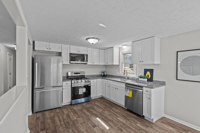 kitchen with a sink, stainless steel appliances, and white cabinetry