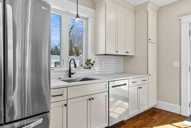 kitchen featuring tasteful backsplash, dark wood finished floors, appliances with stainless steel finishes, white cabinetry, and a sink