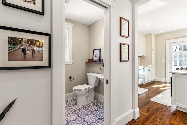 bathroom featuring wood finished floors, toilet, and baseboards