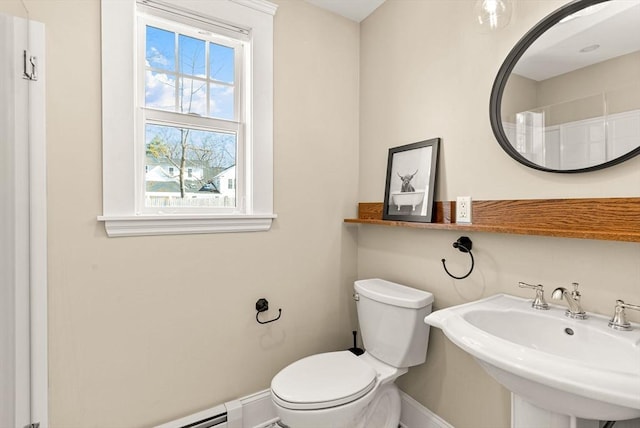 bathroom with a baseboard heating unit, a sink, toilet, and baseboards