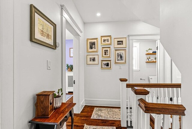 hallway featuring dark wood-type flooring, recessed lighting, an upstairs landing, and baseboards