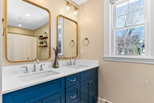 full bathroom featuring a sink, baseboards, and double vanity