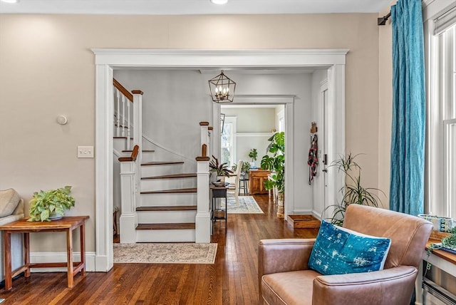 entrance foyer with an inviting chandelier, baseboards, hardwood / wood-style floors, and stairs