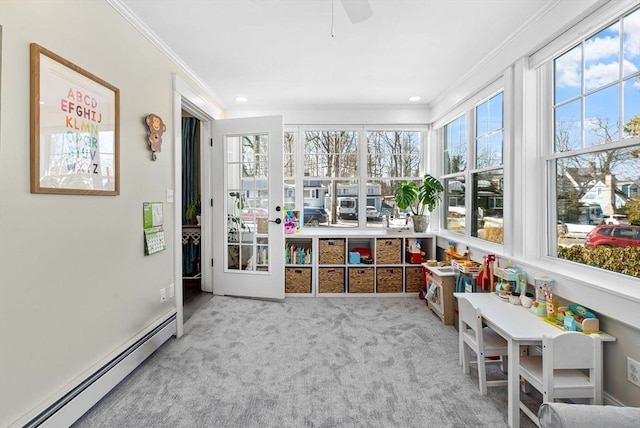 sunroom featuring a baseboard heating unit and ceiling fan