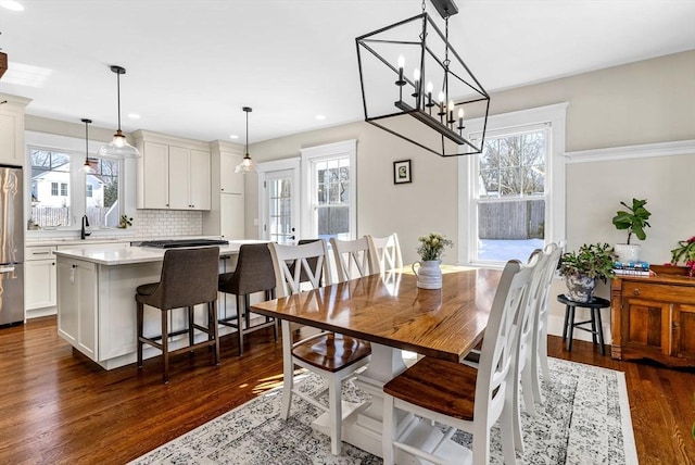 dining area featuring a healthy amount of sunlight, baseboards, dark wood finished floors, and recessed lighting