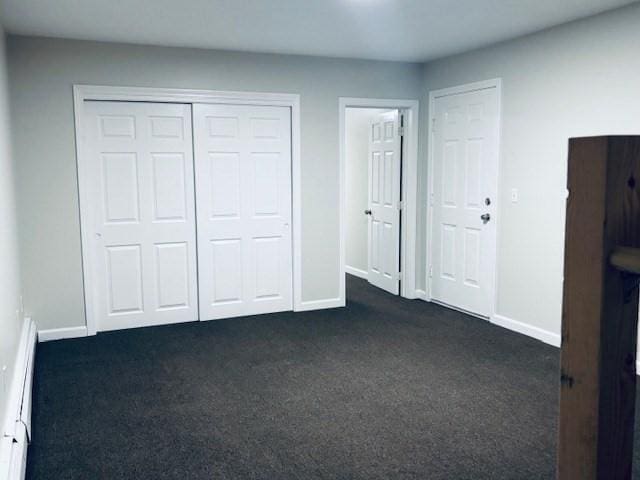 139 E County Rd Unit 139, Rutland, MA 01543 - unfurnished bedroom featuring a baseboard heating unit, dark colored carpet, baseboards, and a closet