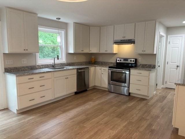 139 E County Rd Unit 139, Rutland, MA 01543 - kitchen with appliances with stainless steel finishes, under cabinet range hood, a sink, light wood-style floors, and hanging light fixtures